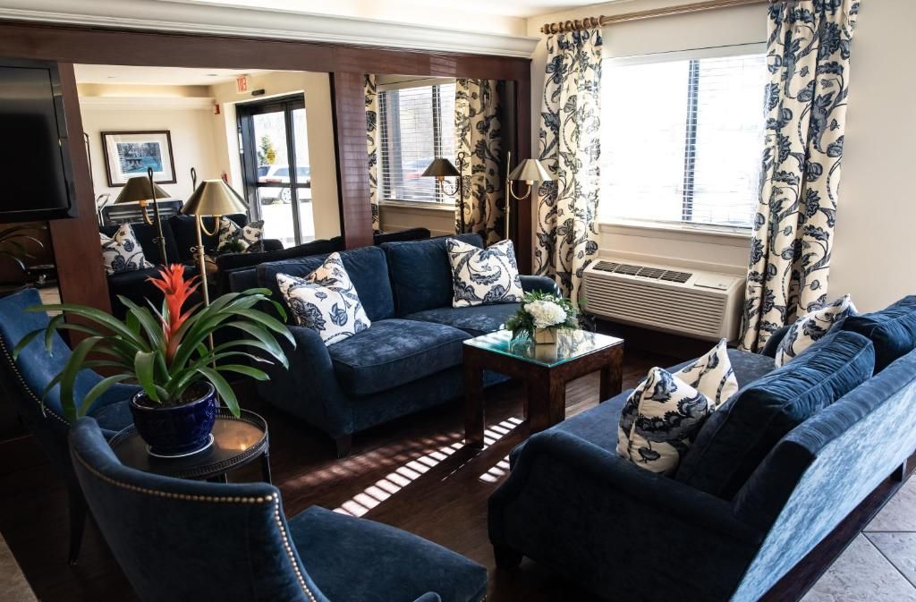 Cozy living room with navy sofas and floral curtains.